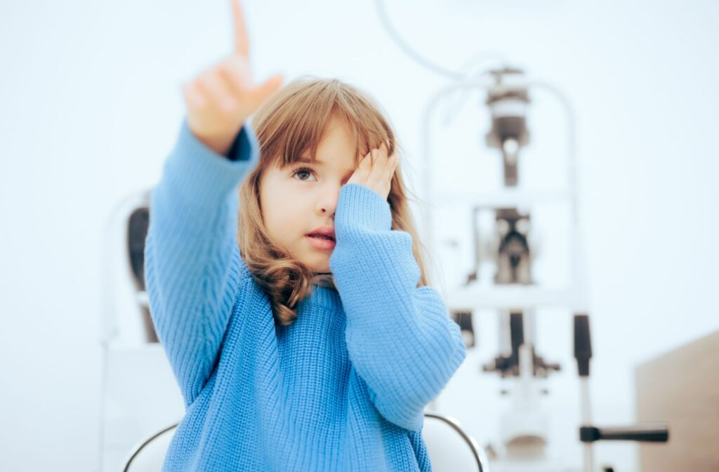 A young girl performing an eye exam at the optometrist's office to see if she has myopia (nearsightedness).